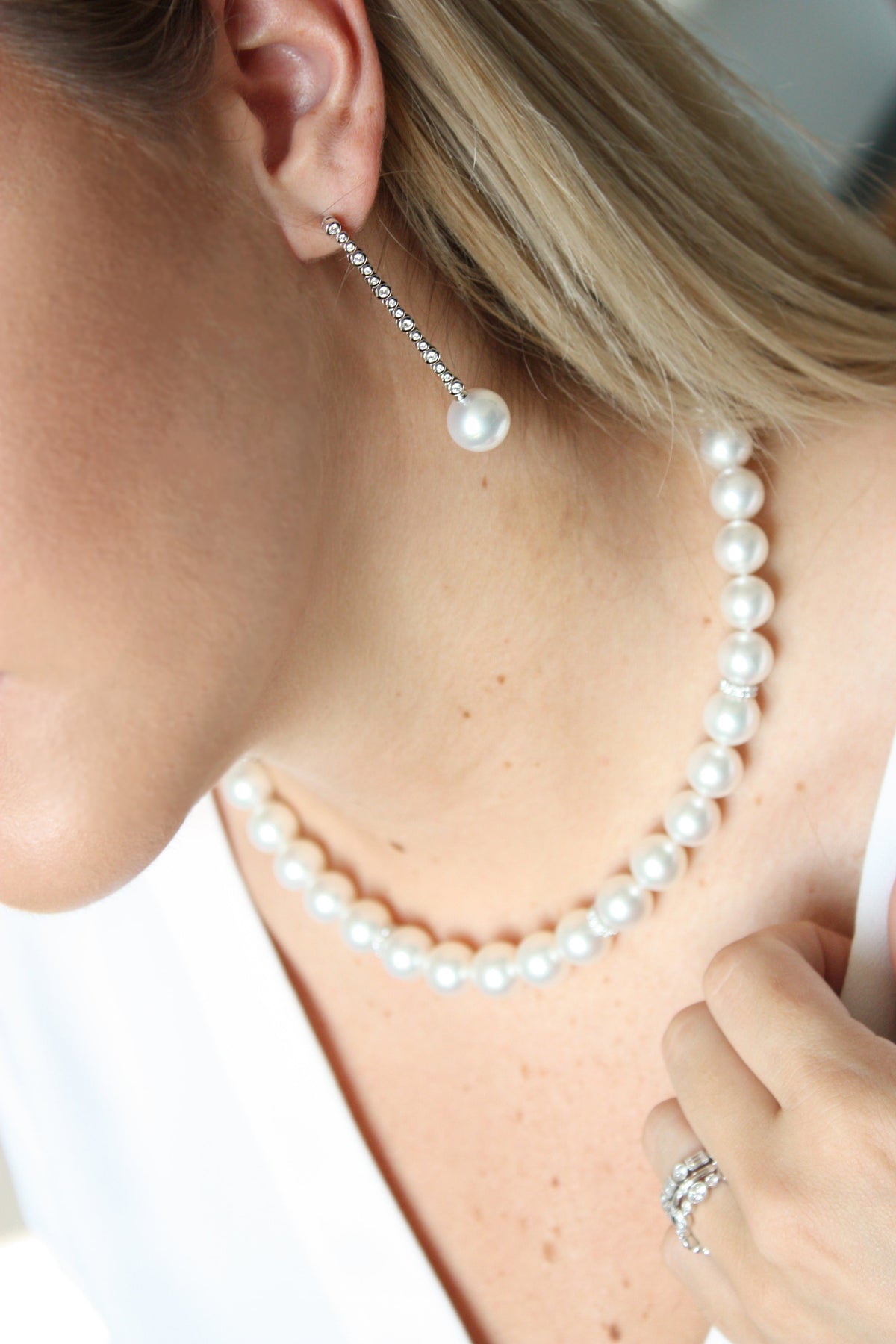 Woman wearing classic pearl necklace and drop earrings