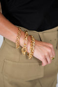 Woman Wearing Three Large Gold Chain Bracelets
