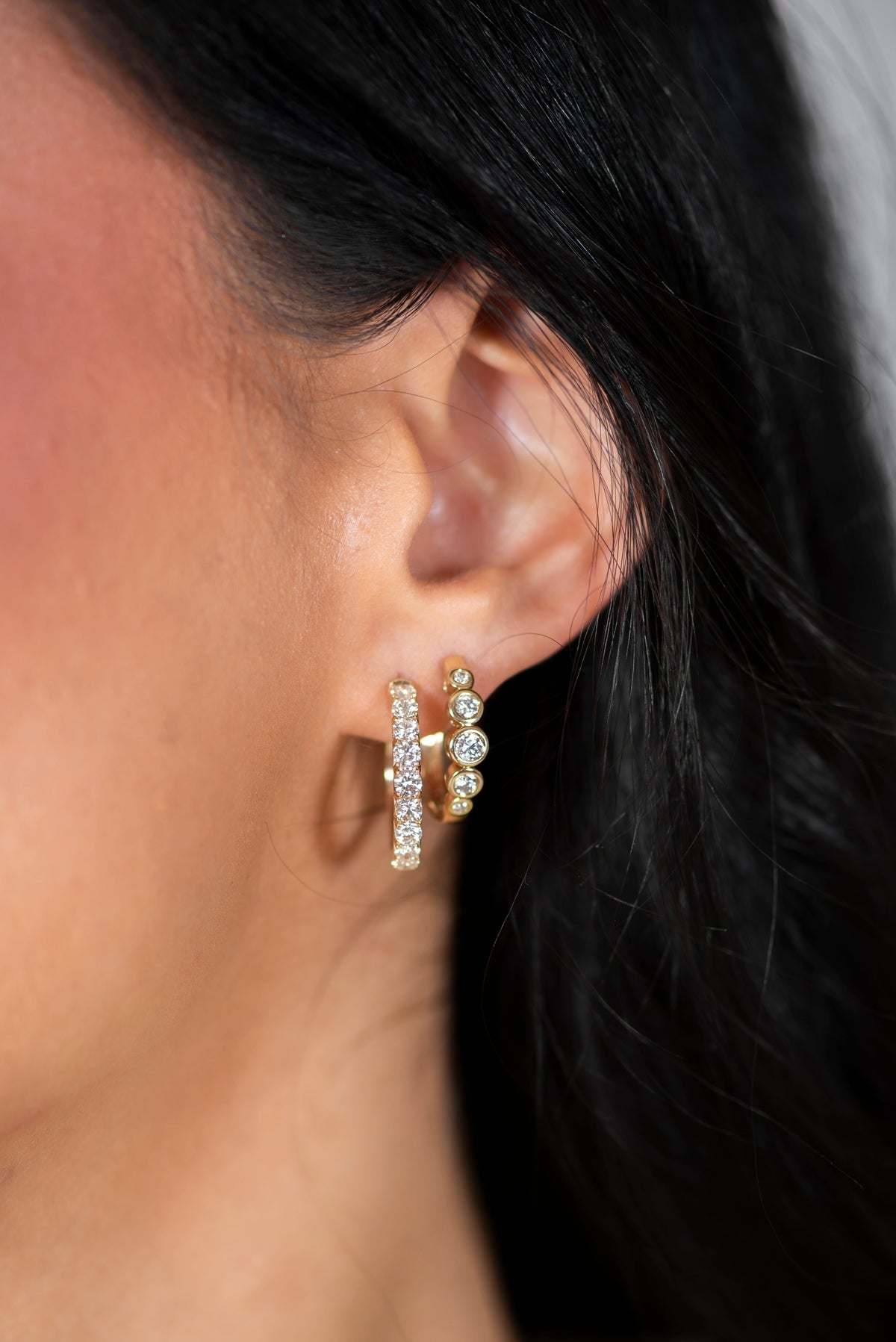Woman wearing two pair of hoops in an earring stack
