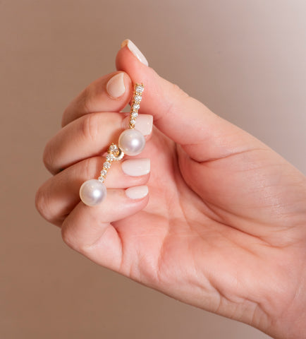 Woman Holding Pearl and Diamond Earrings from Fink's Jewelers