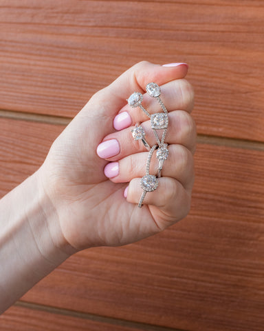 Woman with Pink Nails Displaying 7 Diamond Rings