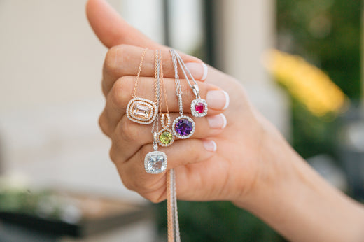 Woman holding birthstone pendants 