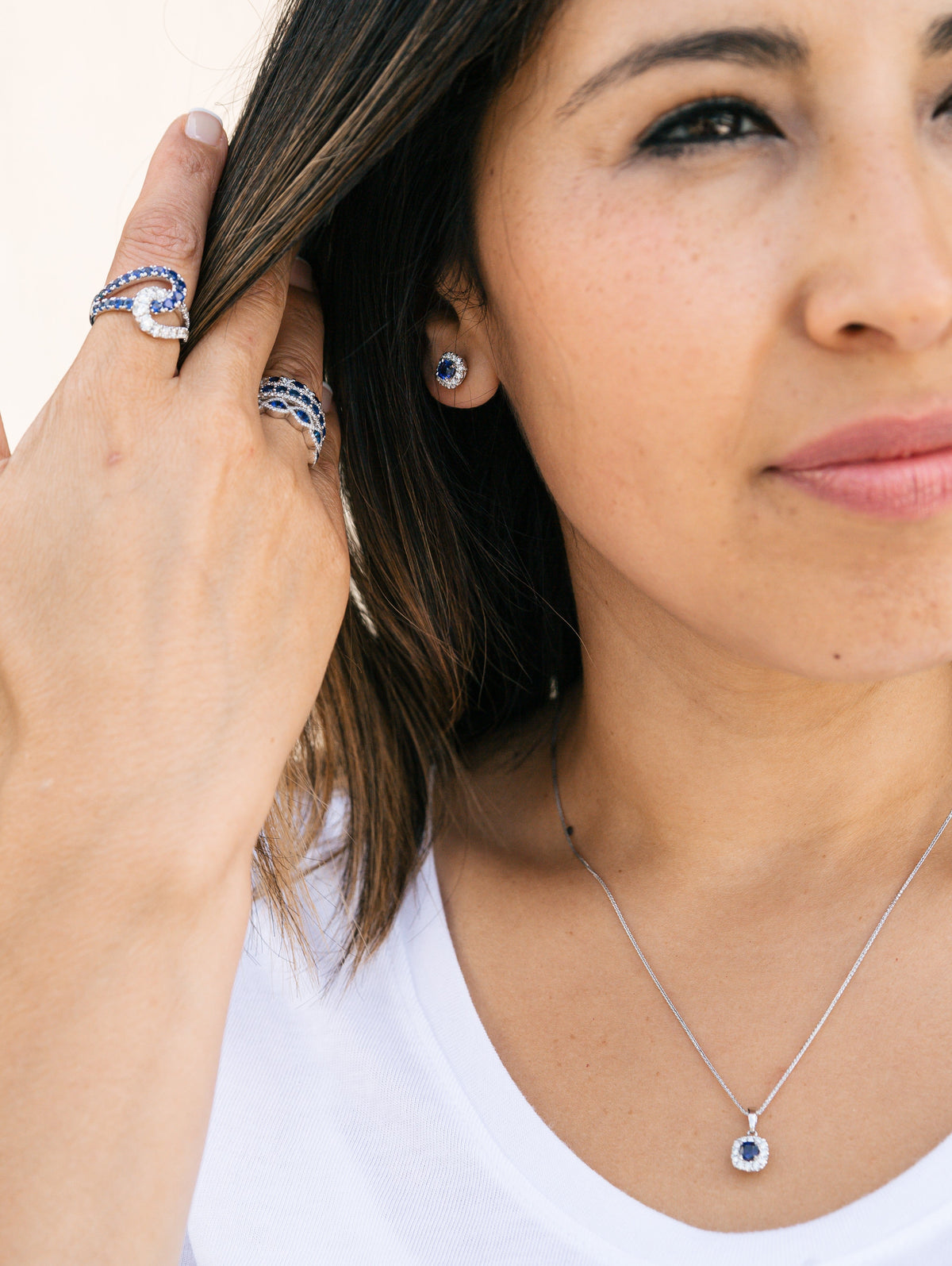 Model Wearing Sapphire rings, earrings and necklace from Fink's Jewelers