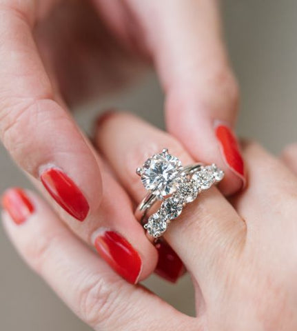 Woman Putting Engagement Ring and Wedding Band on Finger