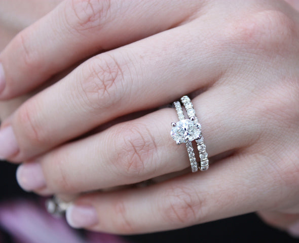 Woman wearing engagement ring and diamond wedding band