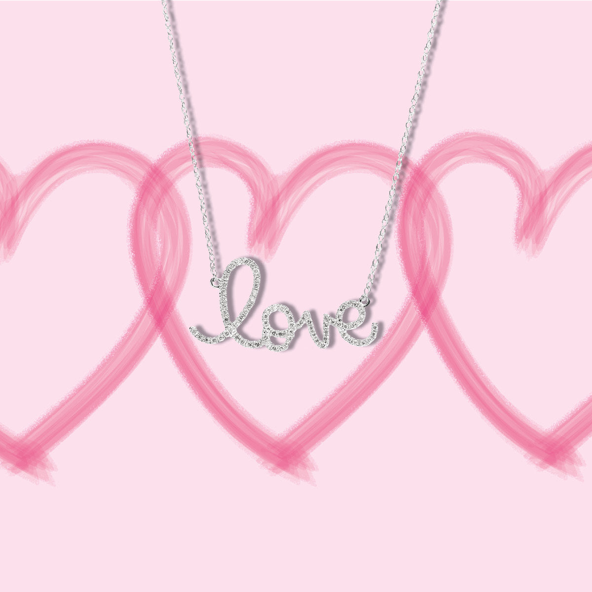 Diamond "love" necklace in front of pink heart background