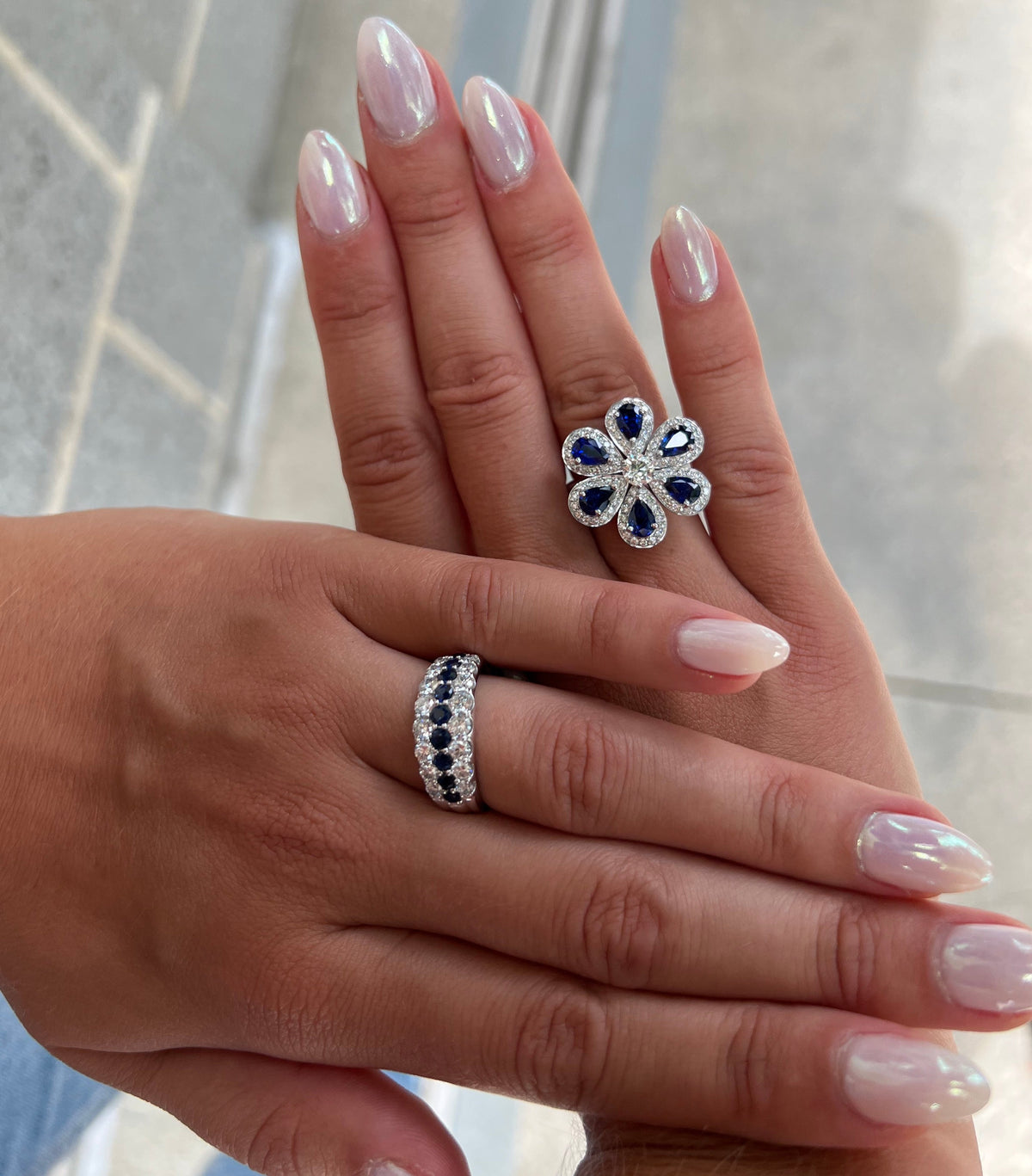 Woman wearing two diamond and sapphire rings