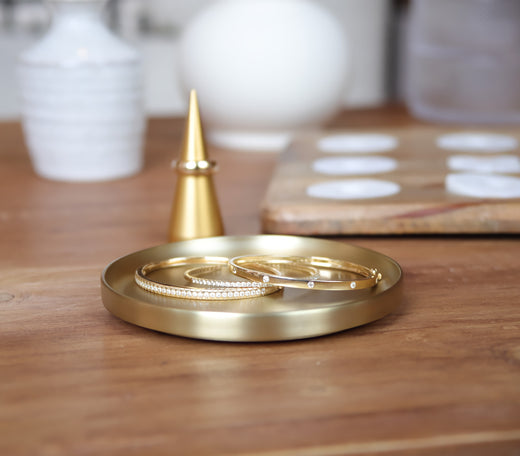 Jewelry storage tray with 14k gold bangles and earrings