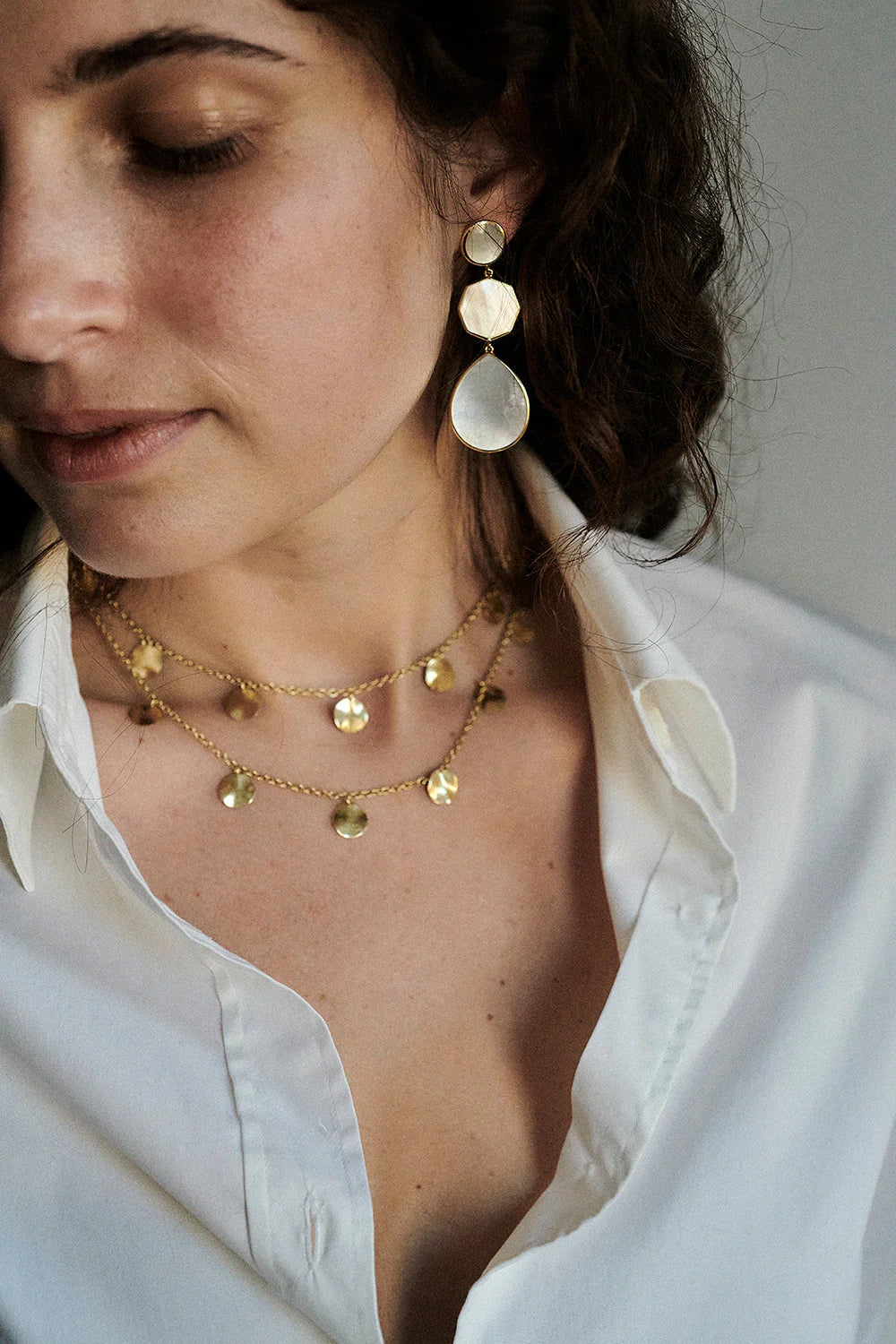 Model wearing IPPOLITA earrings and layered necklace