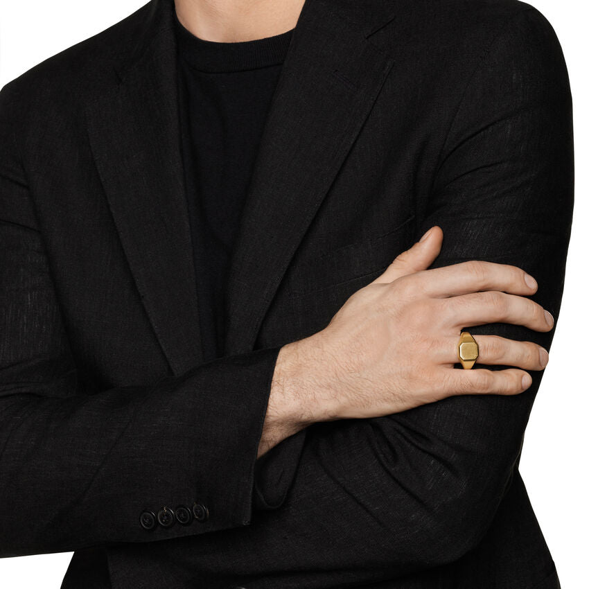 Model in black suit wearing gold signet ring