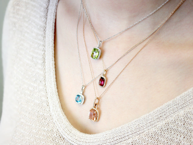 Woman wearing four birthstone pendant necklaces from Fink's Jewelers
