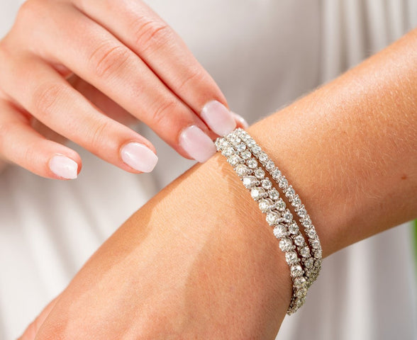 Woman wearing three diamond tennis bracelets