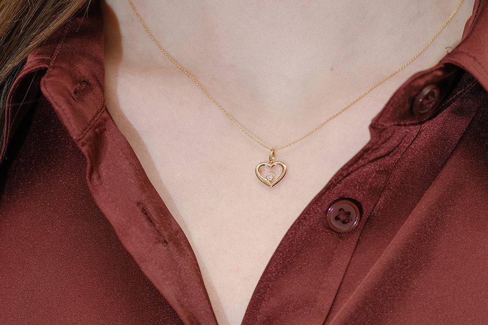 Woman wearing heart pendant necklace with diamond