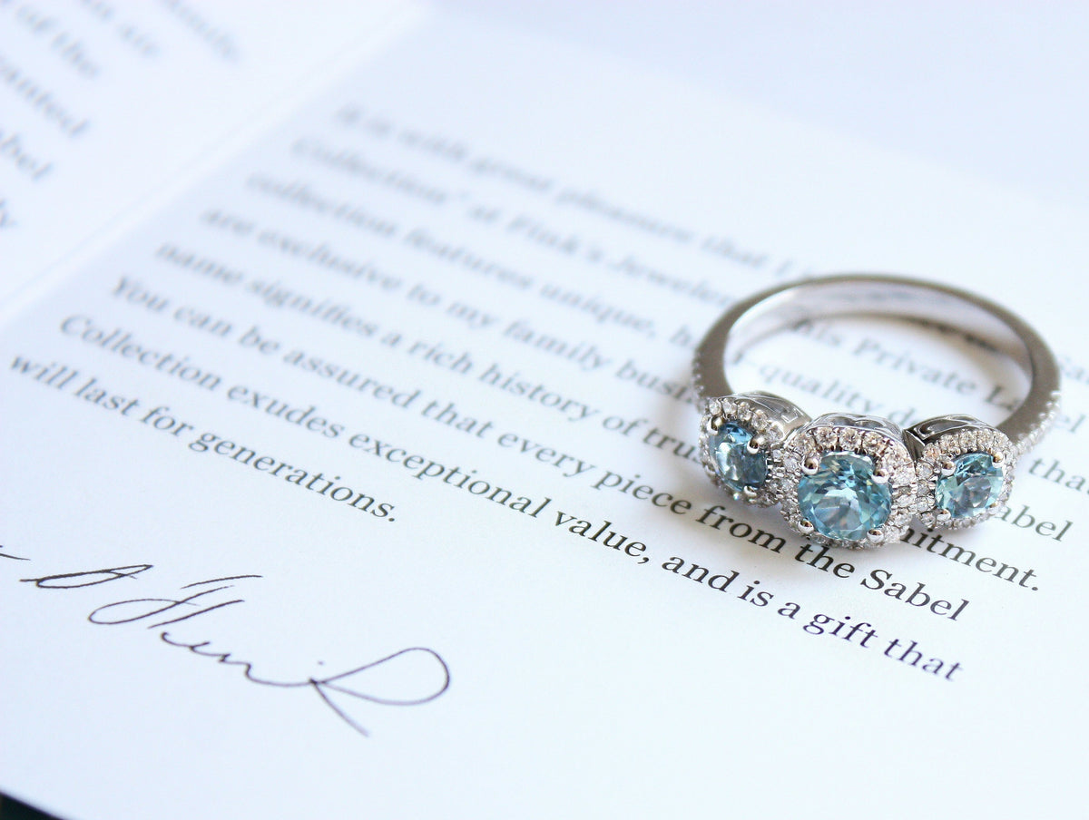 Sable Collection Aquamarine Birthstone Ring Sitting on Note