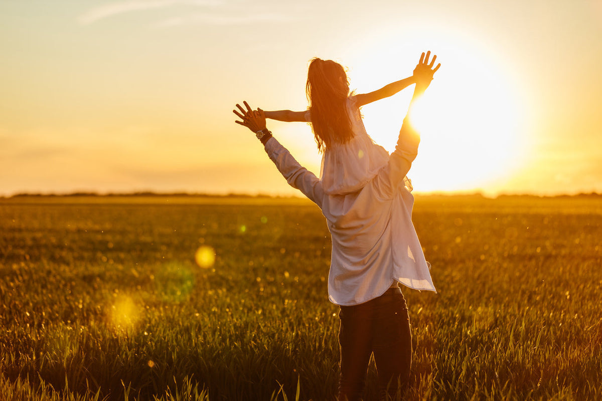 Dad with daughter on his shoulders during sunset