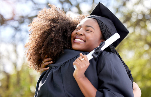 Graduates hug after receiving diplomas