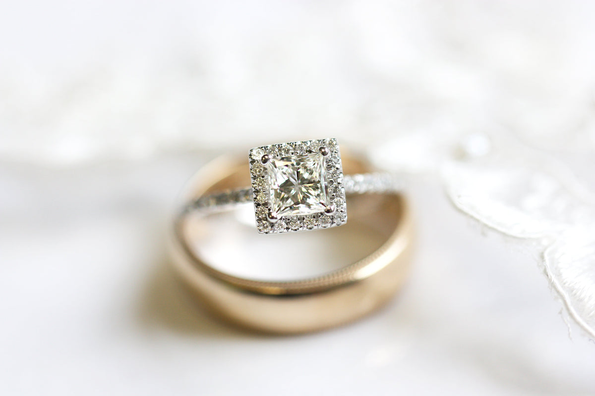 Princess cut diamond engagement ring  and men's yellow gold wedding band from Fink's Jewelers