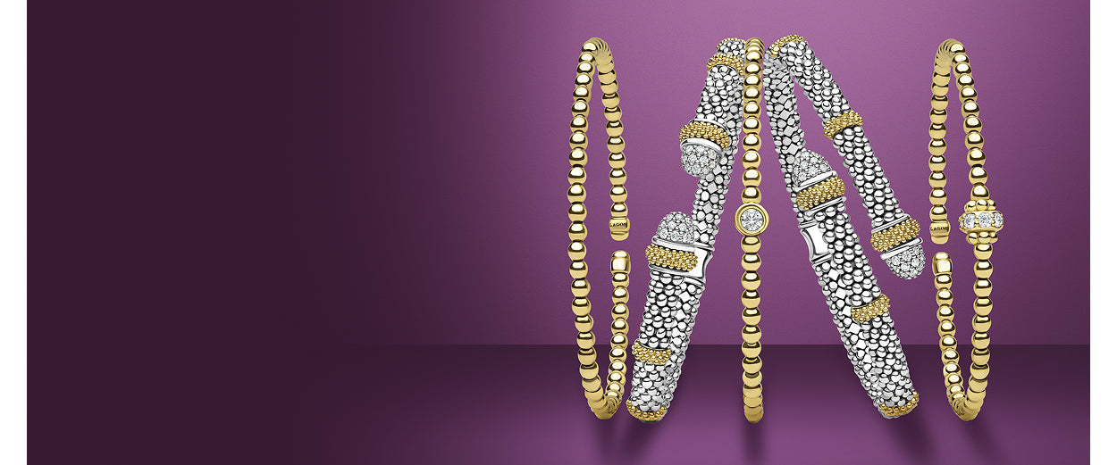 Set of gold and silver bangles on a purple background